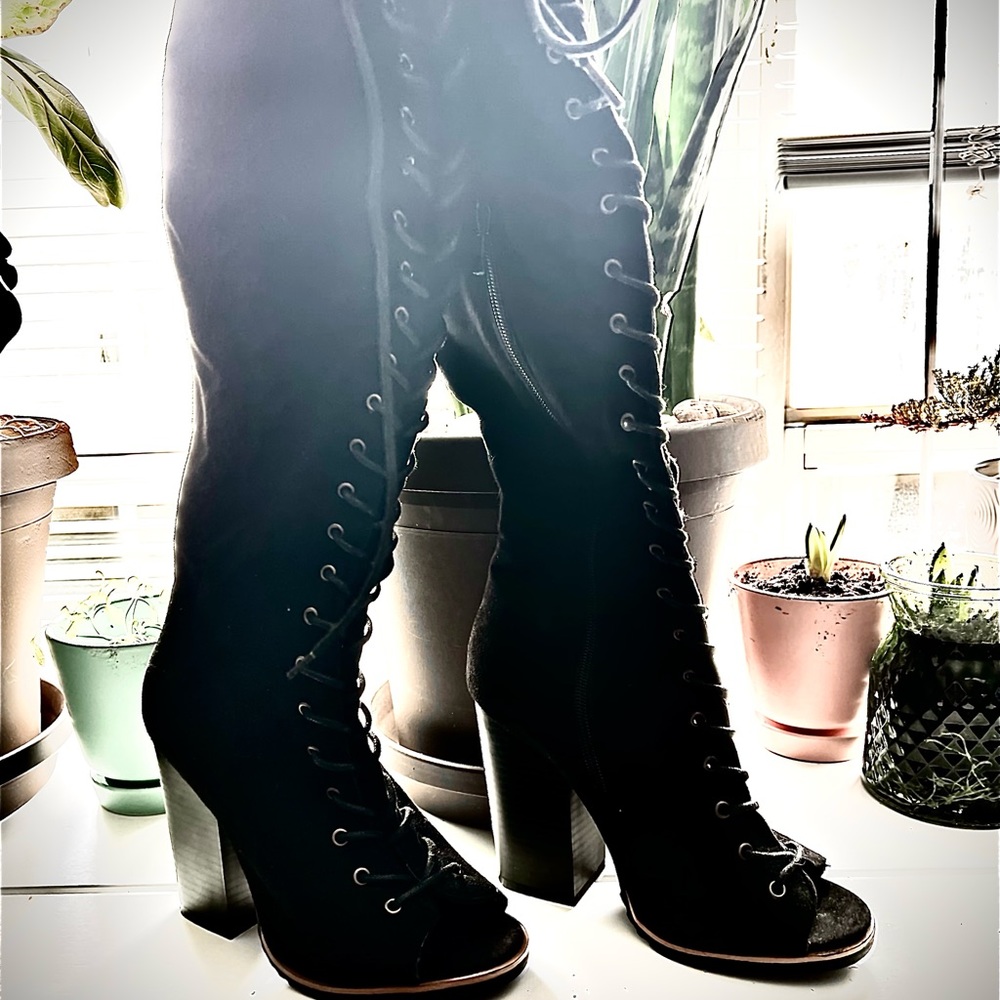 Black thigh high lace up open toe boots with wide heel.